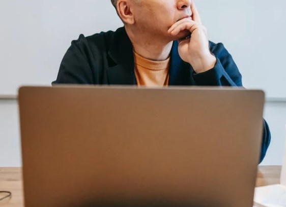 Man thinking in front of laptop